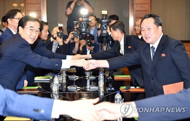 Bộ trưởng Thống nhất Hàn Quốc Cho Myoung-gyon bắt tay ông Ri Son-gwon, Chủ tịch Ủy ban Thống nhất hoà bình của Triều Tiên tại cuộc gặp ngày 13-8. Ảnh: Yonhap.