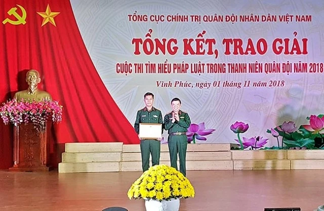 Trung tướng Lê Hiền Vân, Phó Chủ nhiệm Tổng cục Chính trị QĐND Việt Nam (bên phải) trao phần thưởng tặng tác giả đạt giải Nhất cuộc thi.