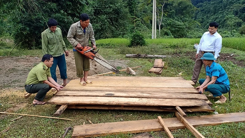 Cán bộ Kiểm lâm khu bảo tồn loài và sinh cảnh Nam Xuân Lạc giúp người dân thôn Kéo Nàng ghép ván tạo khung đổ bê-tông mặt cầu qua suối.