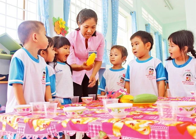 Giáo viên Trường mầm non Phạm Văn Cội 1, huyện Củ Chi, TP Hồ Chí Minh hướng dẫn cho trẻ phân biệt các loại trái cây. Ảnh: HOÀNG NAM