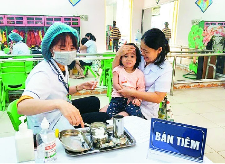 Cán bộ Trung tâm y tế quận Bắc Từ Liêm tiêm bổ sung vắc-xin sởi - rubella cho trẻ em trên địa bàn.
