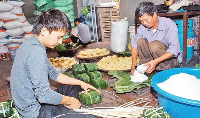 Gói bánh tại làng bánh chưng Tranh Khúc. Ảnh: MINH HÀ