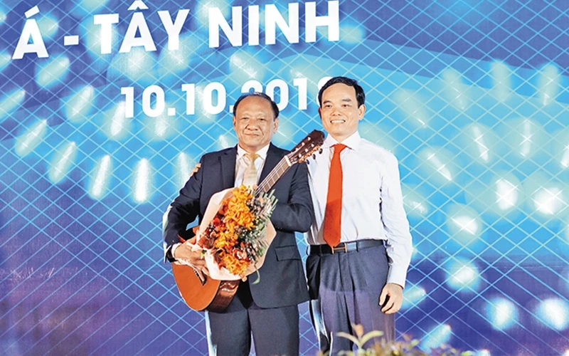 Bí thư Tỉnh ủy Trần Lưu Quang (bên phải) tặng đàn ghi-ta cho một nhà đầu tư.