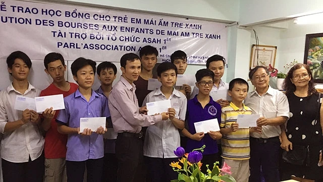 Ông Nguyễn Thanh Tòng (thứ 2, phải sang) trao học bổng cho trẻ em tại Trung tâm Mái ấm Tre xanh ở TP Hồ Chí Minh.