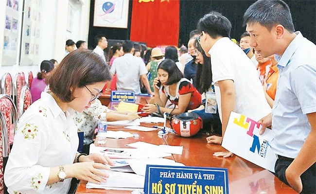 Phụ huynh mua hồ sơ đăng ký tuyển sinh lớp 6 tại Trường THCS - THPT Nguyễn Tất Thành năm học 2018 - 2019. Ảnh: HẢI NGUYỄN