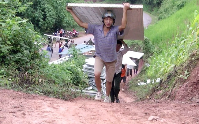 Người dân vùng cao Điện Biên vận chuyển tấm lợp. 