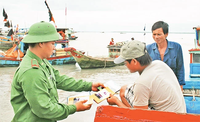 Chiến sĩ Đồn Biên phòng Long Hòa (Bộ đội Biên phòng TP Hồ Chí Minh) xuống tận thuyền tuyên truyền, vận động ngư dân chấp hành tốt quy định của pháp luật.