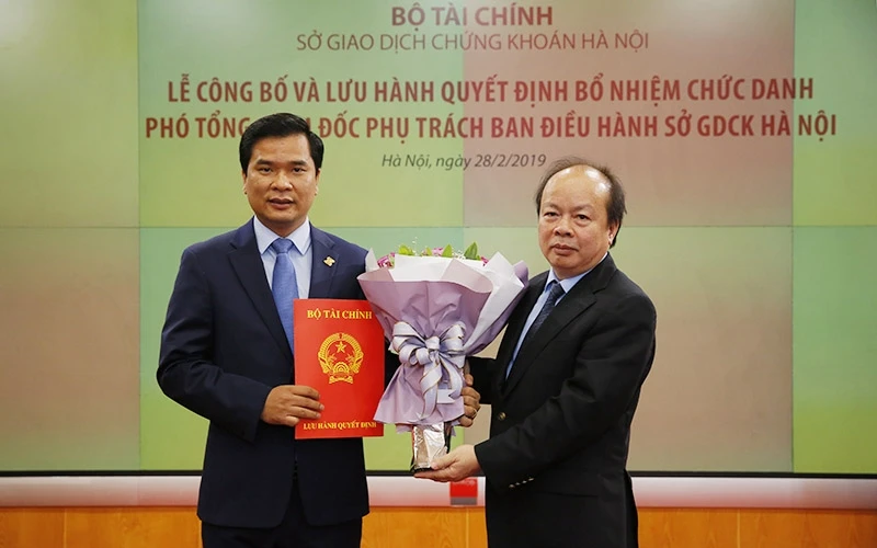 Thứ trưởng Huỳnh Quang Hải (bên phải) trao quyết định đối với ông Nguyễn Như Quỳnh. Ảnh: HNX.