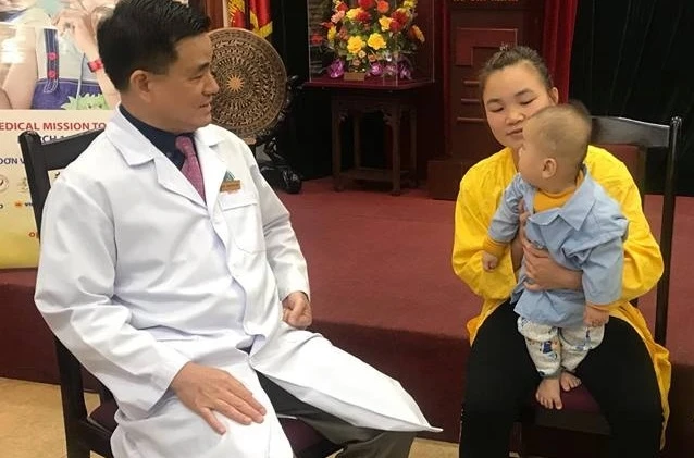 GS Trịnh Đình Hải thăm hỏi các em bé trước khi phẫu thuật. 