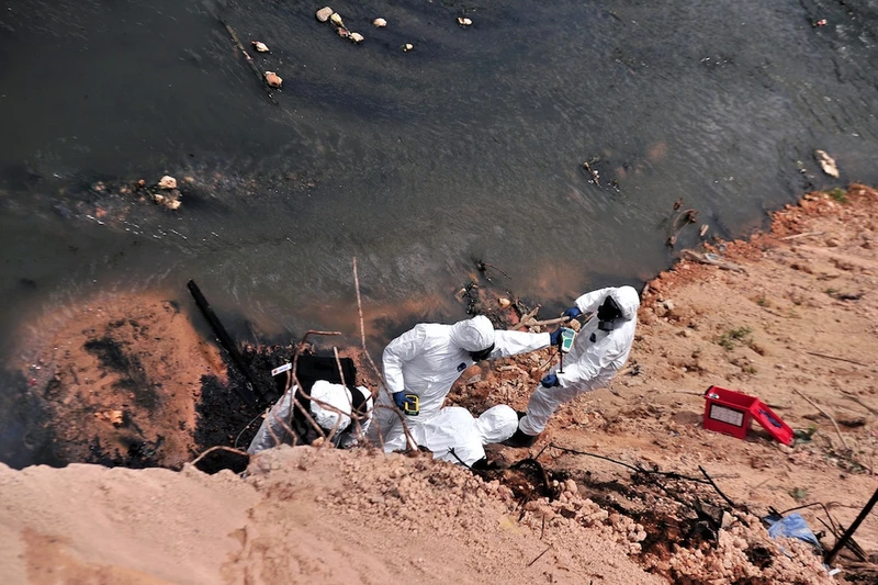 Các công nhân của nhà thầu được chỉ định nạo vét chất thải hóa chất ở sông Sungai Kim Kim (Ảnh: Malaymail)