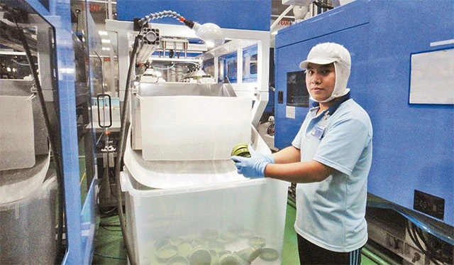 Công nhân Công ty cổ phần sản xuất nhựa Duy Tân (quận Tân Bình) kiểm tra sản phẩm mới hoàn thành.