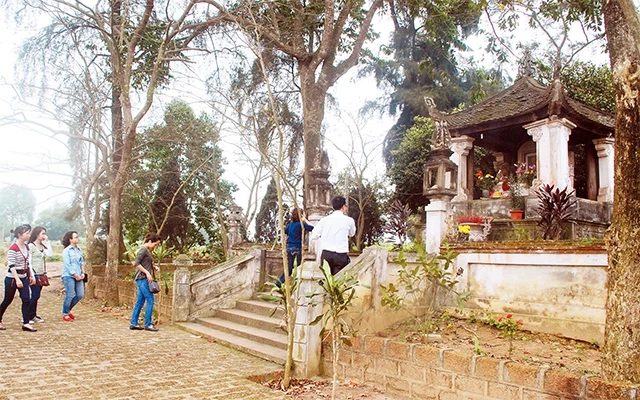 Du khách tham quan di tích lăng Ngô Quyền tại làng Đường Lâm (Sơn Tây). Ảnh: ĐĂNG ANH