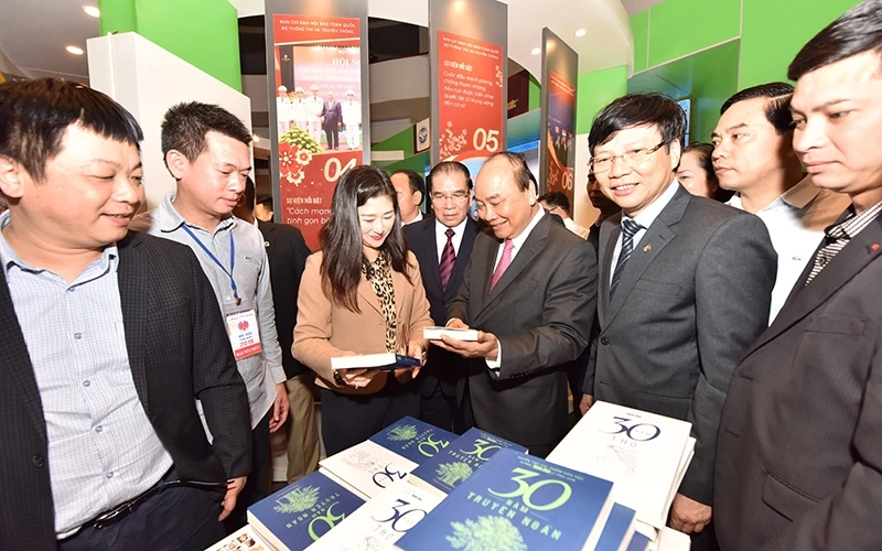 Thủ tướng Nguyễn Xuân Phúc thăm gian trưng bày của Báo Nhân Dân tại Hội báo toàn quốc năm 2019. Ảnh: Duy Linh.