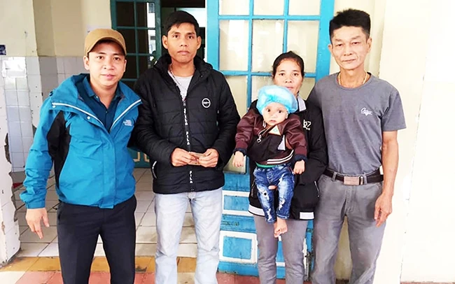 Lê Văn Đinh (bên trái) trao 170 triệu đồng giúp chữa bệnh cho cháu Hồ Thanh Lương, 1 tuổi, ở xã A Ngo, huyện Đakrông.