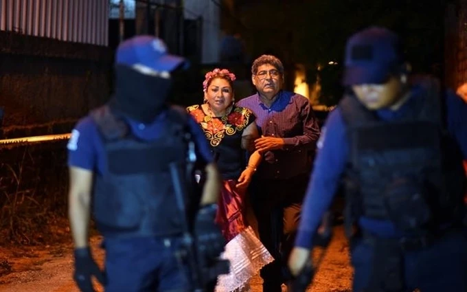 Người dân quan sát cảnh sát bảo vệ hiện trường vụ nổ súng tại quán bar ở TP Minatitlan, bang Veracruz, Mexico, ngày 19-4. (Ảnh: Reuters)
