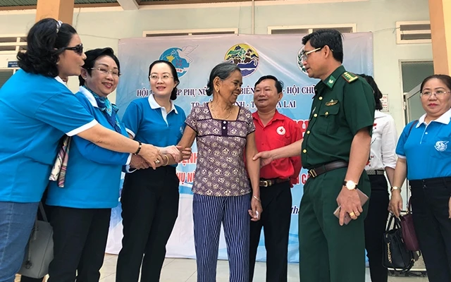 Ðại tá Tô Danh Út và đồng chí Nguyễn Hoàng Ân trao quà cho bà con người dân tộc Gia Rai nghèo diện chính sách ở Gia Lai.
