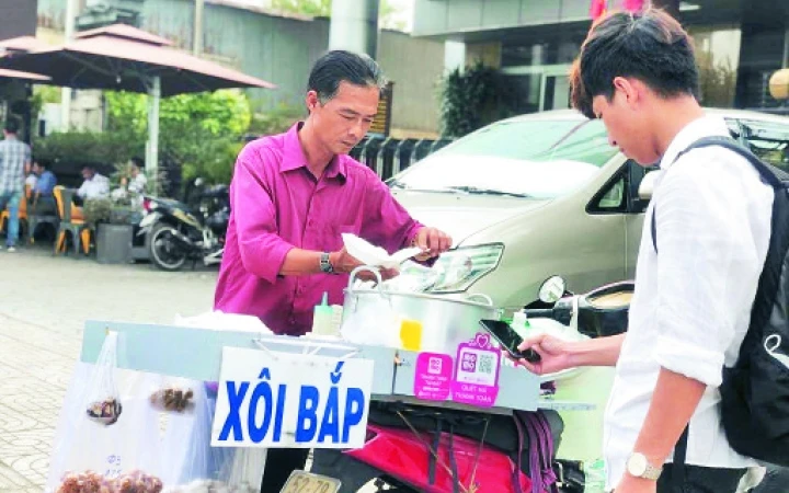 Người tiêu dùng thanh toán mua hàng bằng ví điện tử tại phố hàng rong Nguyễn Văn Chiêm (quận 1).