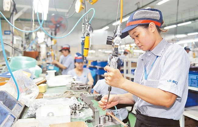 Công nhân Công ty Juki (Khu chế xuất Tân Thuận, quận 7) lắp ráp máy may bằng thiết bị, công nghệ hiện đại.