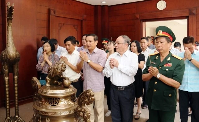 Đại sứ Nguyễn Bá Hùng (giữa) và cán bộ, nhân viên các cơ quan đại diện Việt Nam tại Lào thắp hương tưởng nhớ công lao to lớn của Bác Hồ, ngày 19-5. 