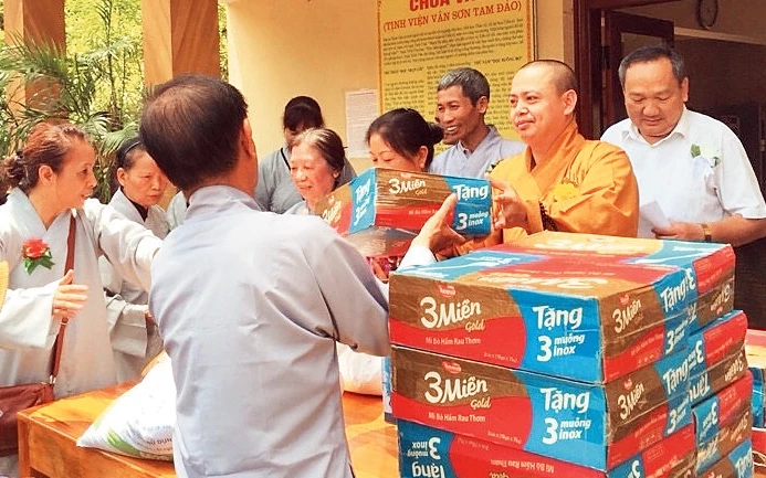 Ðại đức Thích Thanh Phương (thứ hai từ phải sang) trao quà tặng hộ nghèo tại chùa Vân, huyện Tam Ðảo (Vĩnh Phúc).