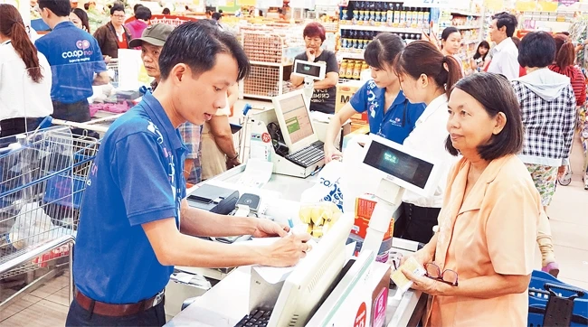 Người tiêu dùng thanh toán bằng thẻ ATM khi mua hàng tại siêu thị Co.opmart ở TP Hồ Chí Minh.