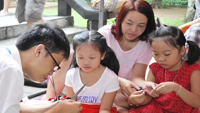 Hướng dẫn trẻ làm đồ thủ công, phát triển kỹ năng sáng tạo. Ảnh: HẢI NAM