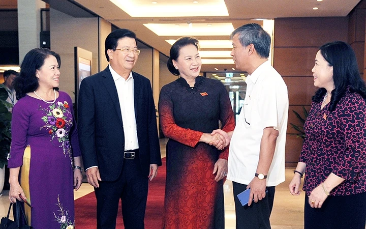 Chủ tịch Quốc hội Nguyễn Thị Kim Ngân trao đổi ý kiến với các đại biểu bên hành lang hội trường. Ảnh: TRẦN HẢI