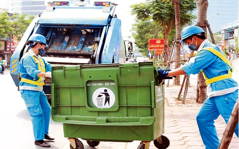 Công nhân Công ty Môi trường Hà Nội thu gom rác thải trên phố Thái Hà. Ảnh: Hoàng Hiệp