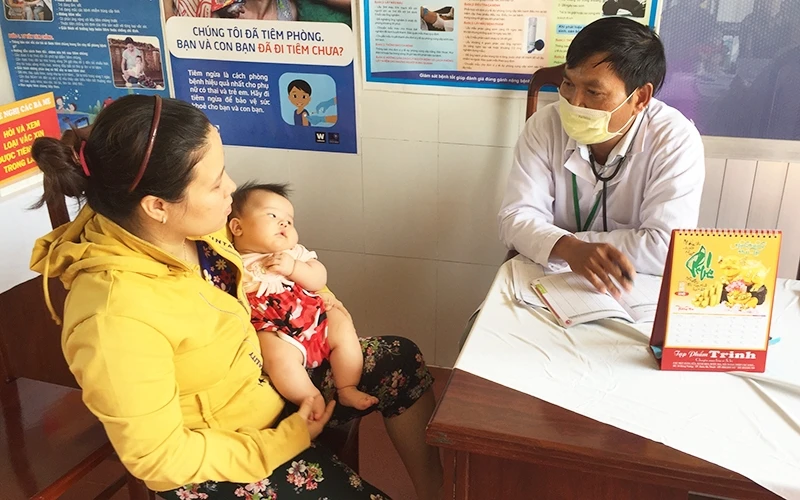 Các y, bác sĩ Trạm y tế xã Cư Êbur, TP Buôn Ma Thuột (Đác Lắc) hướng dẫn người dân cách phòng, chống bệnh SXH cho con. 