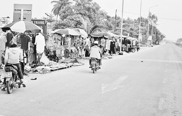 Người mua, người bán lấn chiếm lòng đường, gây cản trở giao thông trên quốc lộ 1A, đoạn qua xã Tịnh Phong, huyện Sơn Tịnh, tỉnh Quảng Ngãi.
