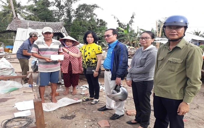 Đại diện chính quyền địa phương hỗ trợ bước đầu cho hộ dân có nhà sập, tốc mái ở xã Khánh Thuận.