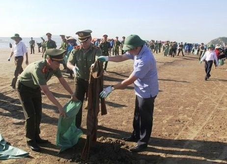Cán bộ, lực lượng công an cùng tham gia thu gom rác thải trên bờ biển Hải Hòa.