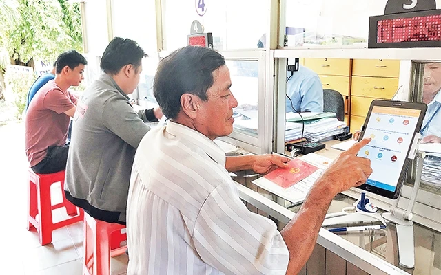 Người dân đánh giá chất lượng phục vụ sau khi làm hồ sơ hành chính tại UBND xã Tân Phú Trung, huyện Củ Chi. Ảnh: THU HÀ