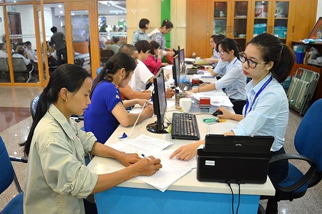 Cán bộ Trung tâm Hành chính công tỉnh Quảng Ninh hướng dẫn người lao động làm thủ tục và hồ sơ hưởng bảo hiểm thất nghiệp. 
