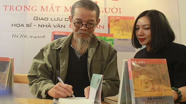 Nhà văn Đỗ Phấn tặng chữ ký cho độc giả trong một buổi giao lưu tại Hà Nội.