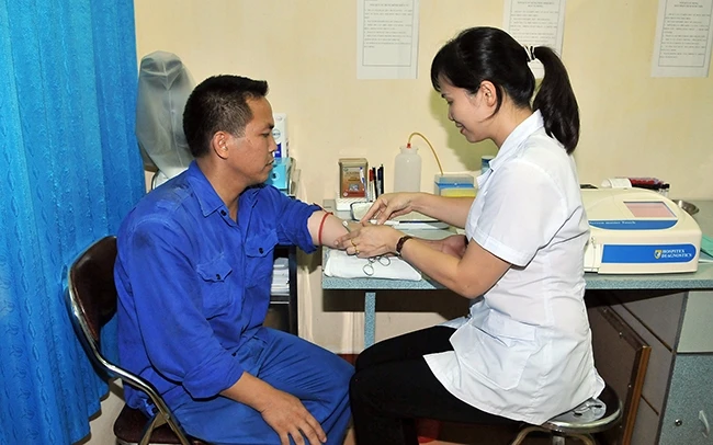 Cán bộ y tế Trạm y tế Nhà máy Z113 (Tuyên Quang) khám, chữa bệnh cho công nhân. Ảnh: NGUYỄN ĐĂNG