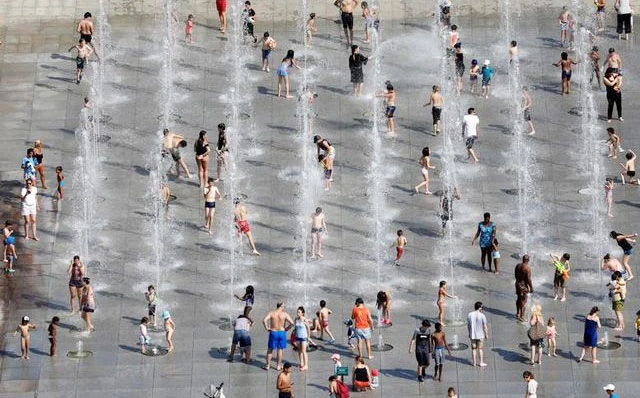 Người dân tránh nóng tại các đài phun nước ở Paris (Pháp). Ảnh: Reuters