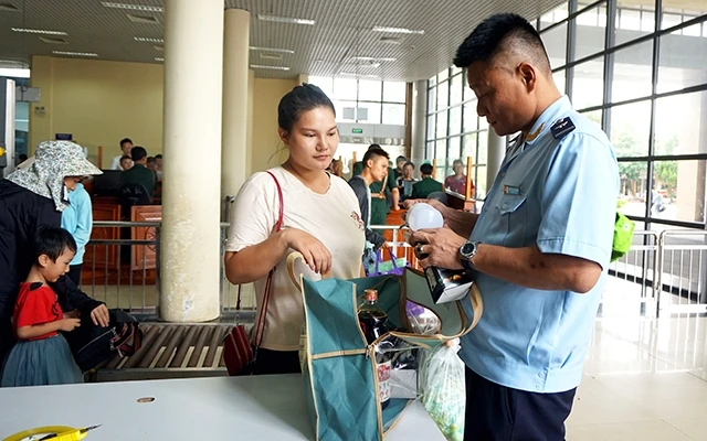 Cán bộ Cục Hải quan tỉnh Quảng Ninh kiểm tra, giám sát hàng hóa của du khách nhập cảnh tại cửa khẩu quốc tế Móng Cái.