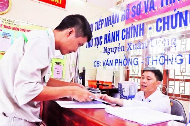 Anh Nguyễn Xuân Đông hướng dẫn người dân làm thủ tục hành chính.