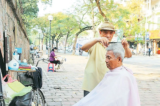 Tiệm cắt tóc tại vỉa hè phố Văn Miếu. Ảnh: NHUNG HÀ