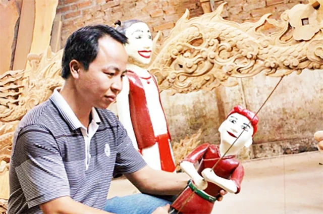Nghệ nhân Nguyễn Văn Viên bên con rối nước.