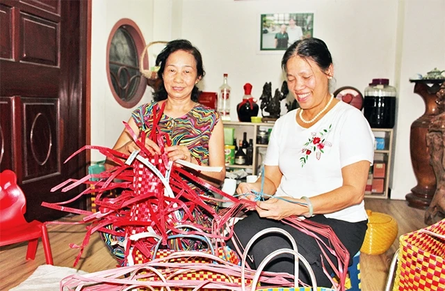 Bà Nguyễn Thị Túc (áo trắng) đan làn nhựa cùng hội viên Chi hội phụ nữ số 5 (quận Tây Hồ).