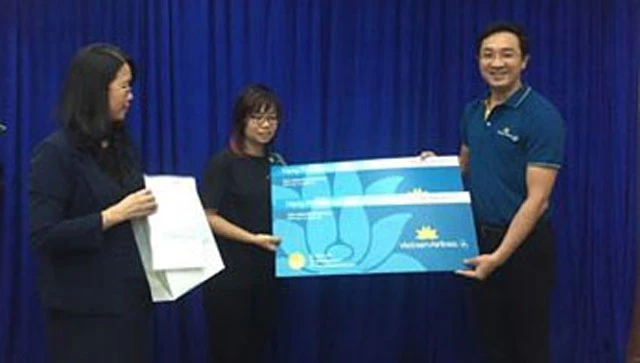 Lãnh đạo Sở Du lịch TP Hồ Chí Minh và đại diện hãng hàng không Vietnnam Airlines trao vé quà tặng cho người nhà cụ Oki.