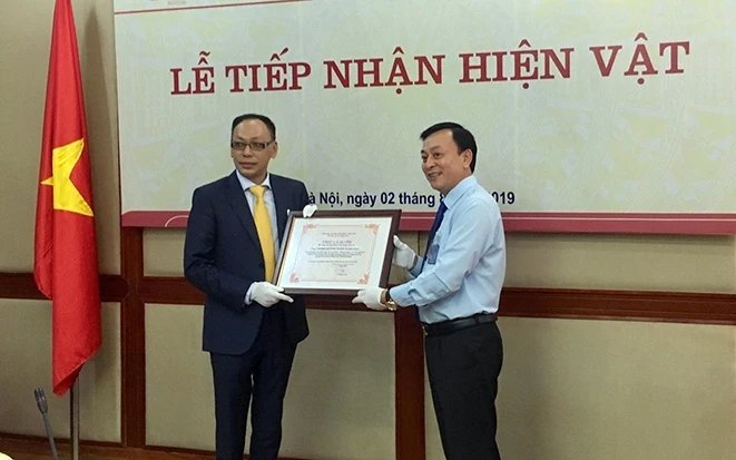 Ðại diện Bảo tàng Hồ Chí Minh (bên phải) trao Thư cảm ơn ông Vương Quỳnh Xuân.
