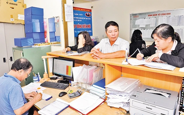 Người dân làm thủ tục xin cấp giấy chứng nhận quyền sử dụng đất tại Văn phòng đăng ký đất đai thị xã Sơn Tây. Ảnh: ÐĂNG ANH