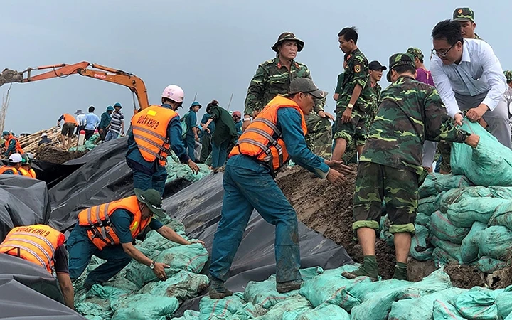 Lực lượng chức năng gia cố một đoạn đê biển Tây (tỉnh Cà Mau) bị sóng đánh sạt lở nghiêm trọng. Ảnh: GIA BÁCH