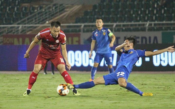 Pha tranh bóng giữa cầu thủ Quảng Nam (áo xanh) và TP Hồ Chí Minh.