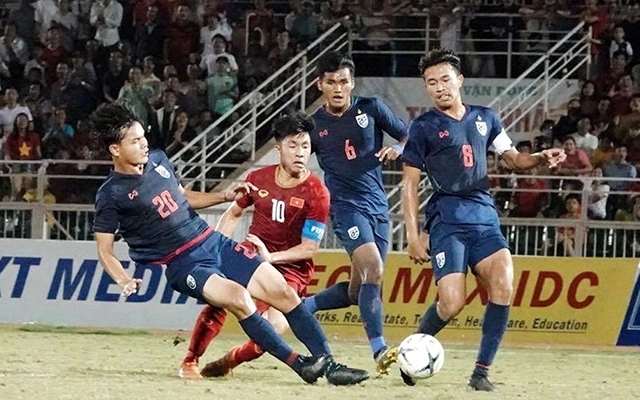 Cầu thủ U18 Việt Nam (áo đỏ) trong vòng vây của các cầu thủ U18 Thái-lan. Ảnh: MAI ANH