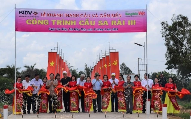 Nguyên Chủ tịch nước Trương Tấn Sang dự lễ cắt băng khánh thành, chính thức đưa vào hoạt động 10 chiếc cầu dân sinh ở huyện Tân Hồng, tỉnh Đồng Tháp.