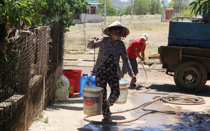 Người dân thôn Phú Tân 2 phấn khởi được nhận những thùng nước hỗ trợ đầu tiên